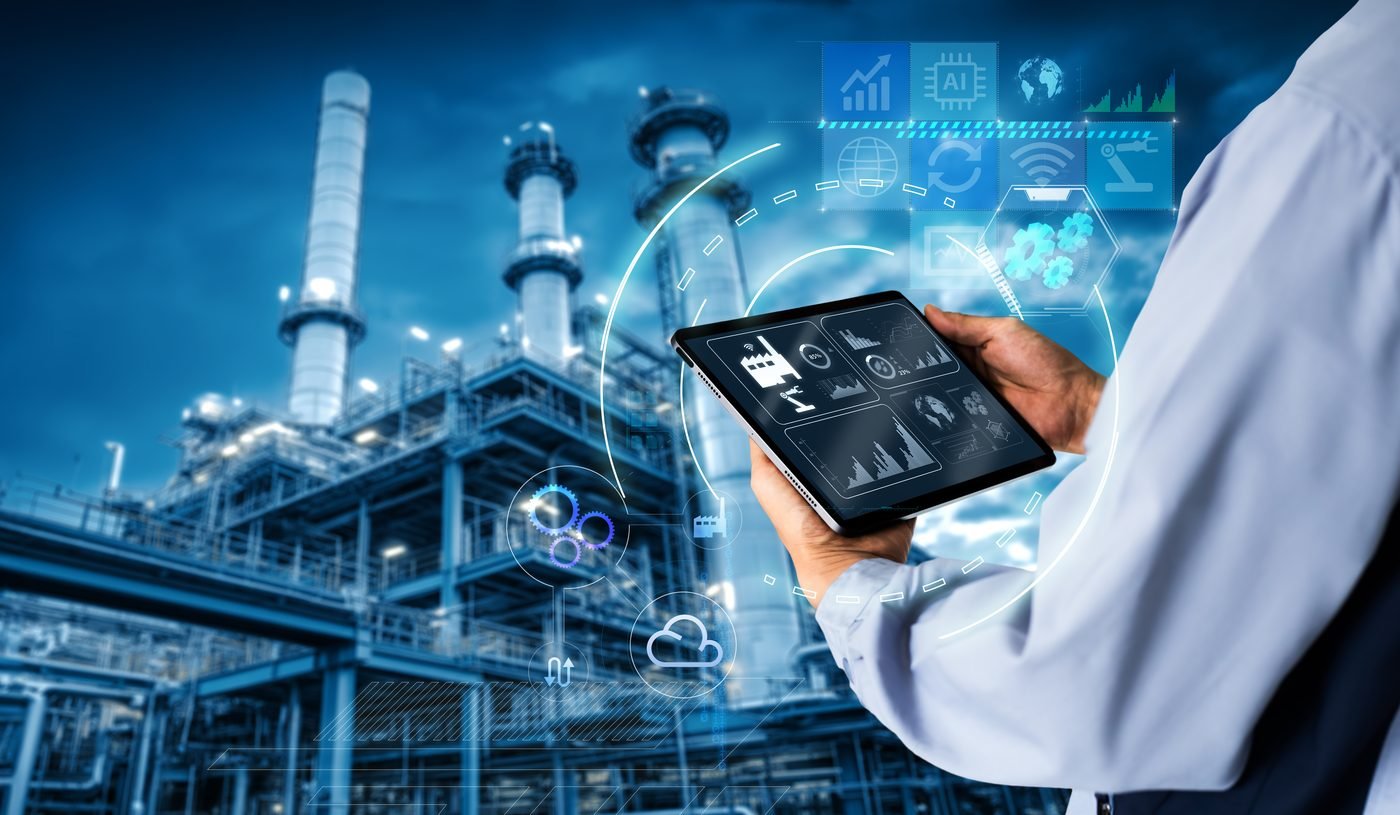Engineer reviewing an industrial IoT dashboard on a tablet at a plant
